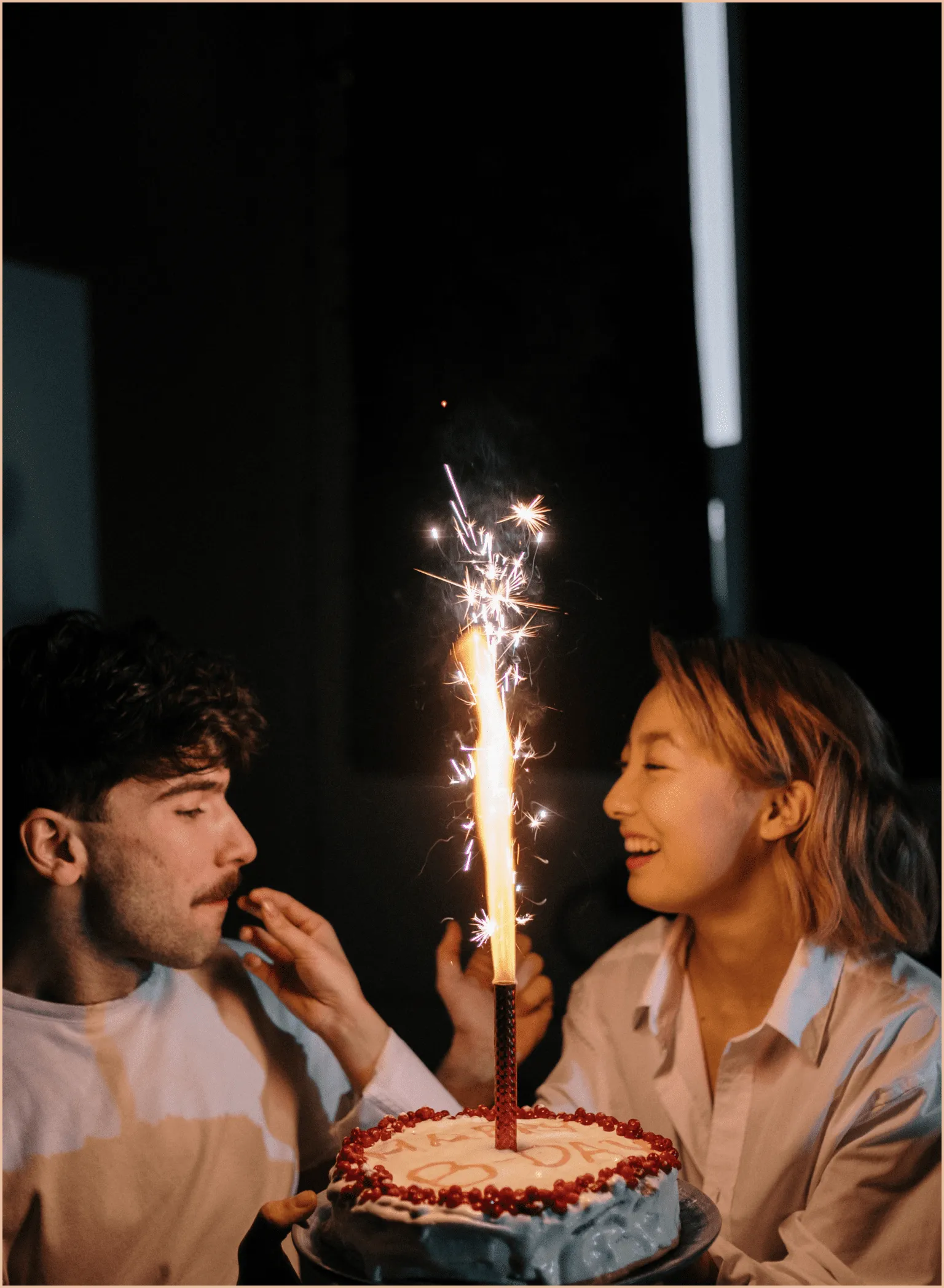 Gateau d’anniversaire avec une bougie au milieu d'un homme et d'une femme.