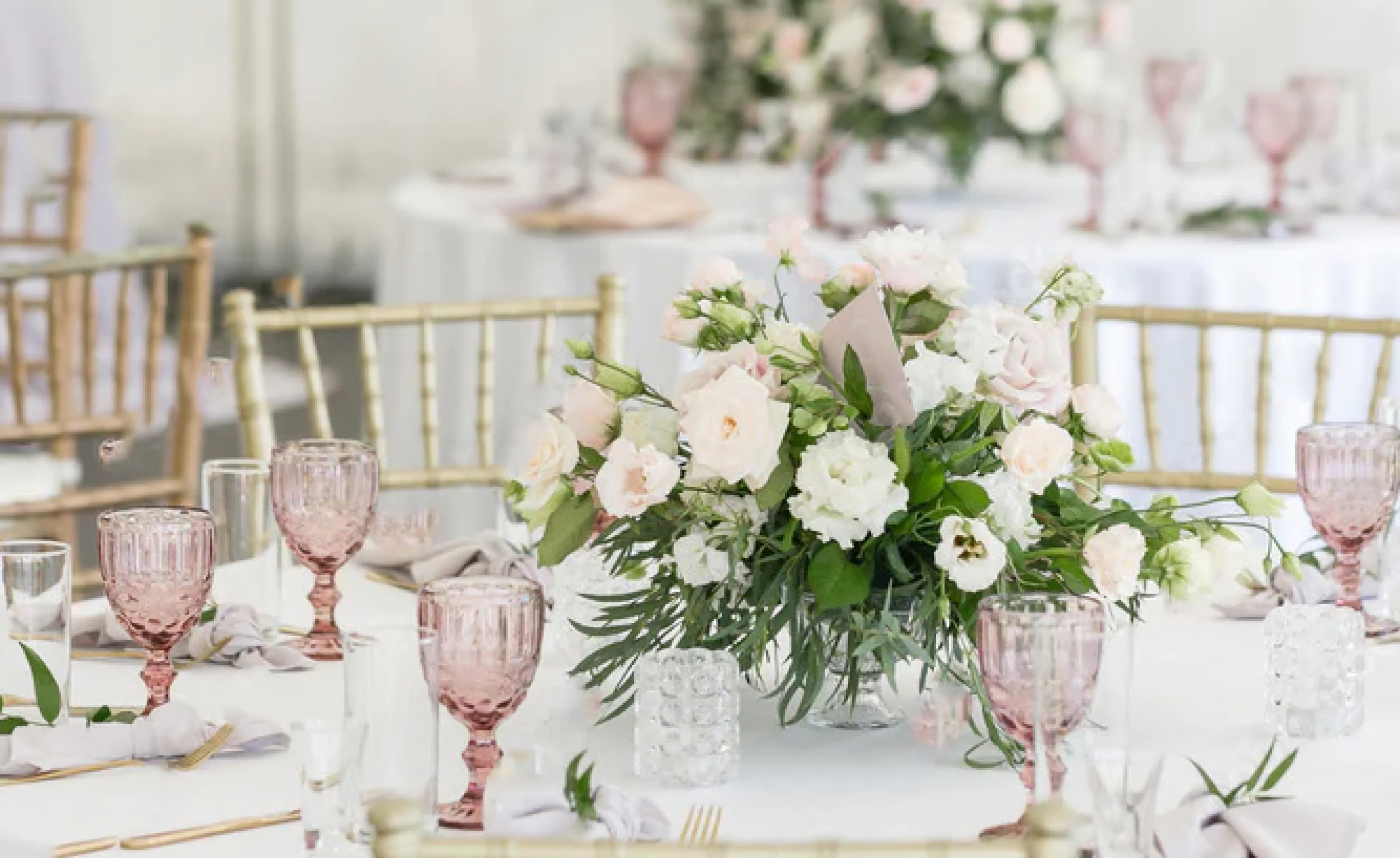 Une table avec des verres et un bouquet de fleur au milieu
